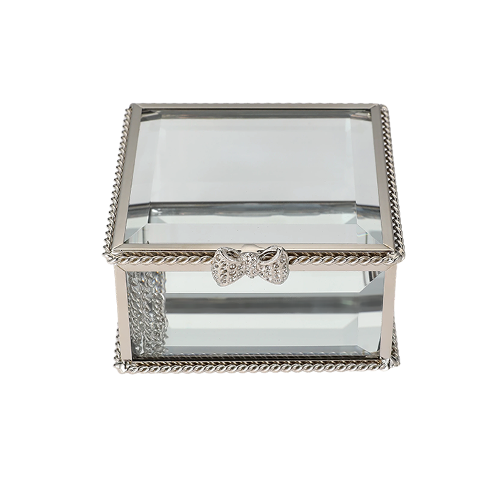 Glass jewelry box with silver decorative bow on a white background
