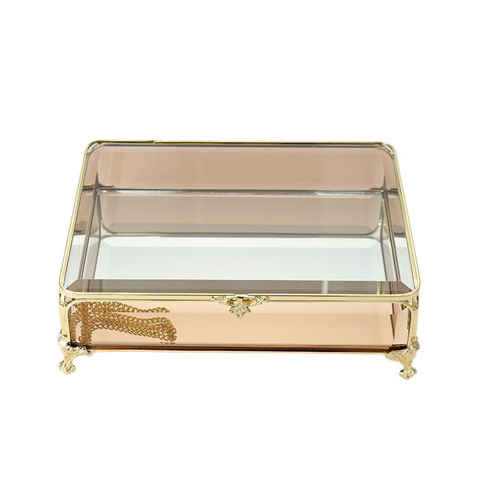 Decorative glass box with gold accents on a white background