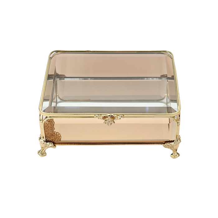 Decorative glass box with gold accents on a white background
