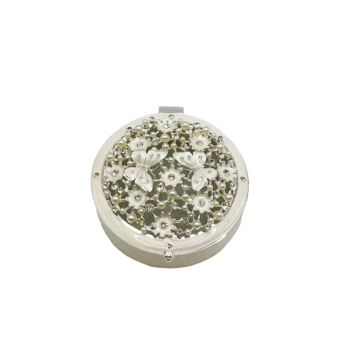 Round decorative box with floral embellishments on a white background