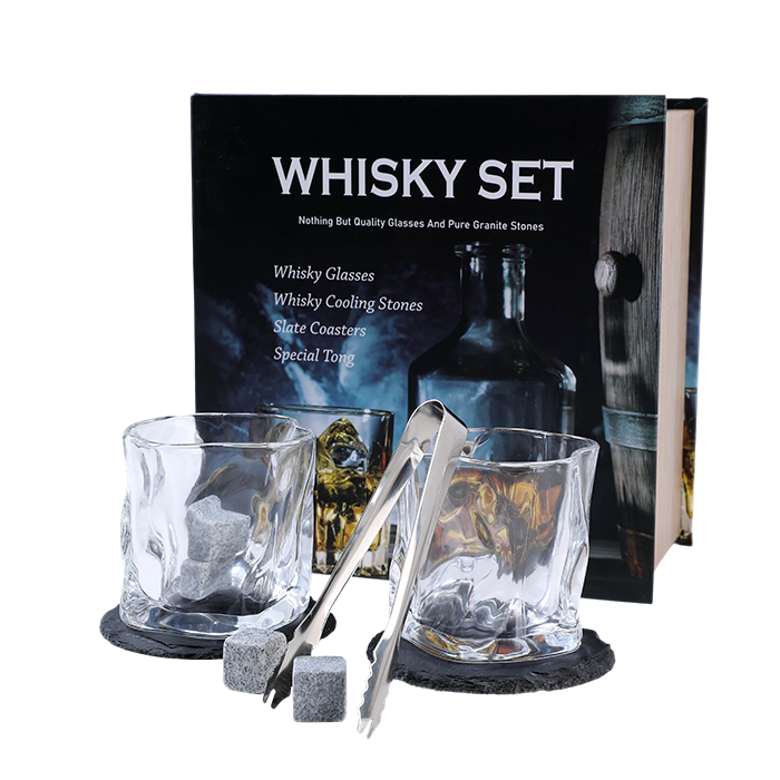 Whisky set with glasses, cooling stones, coasters, and a tong in front of a branded box.
